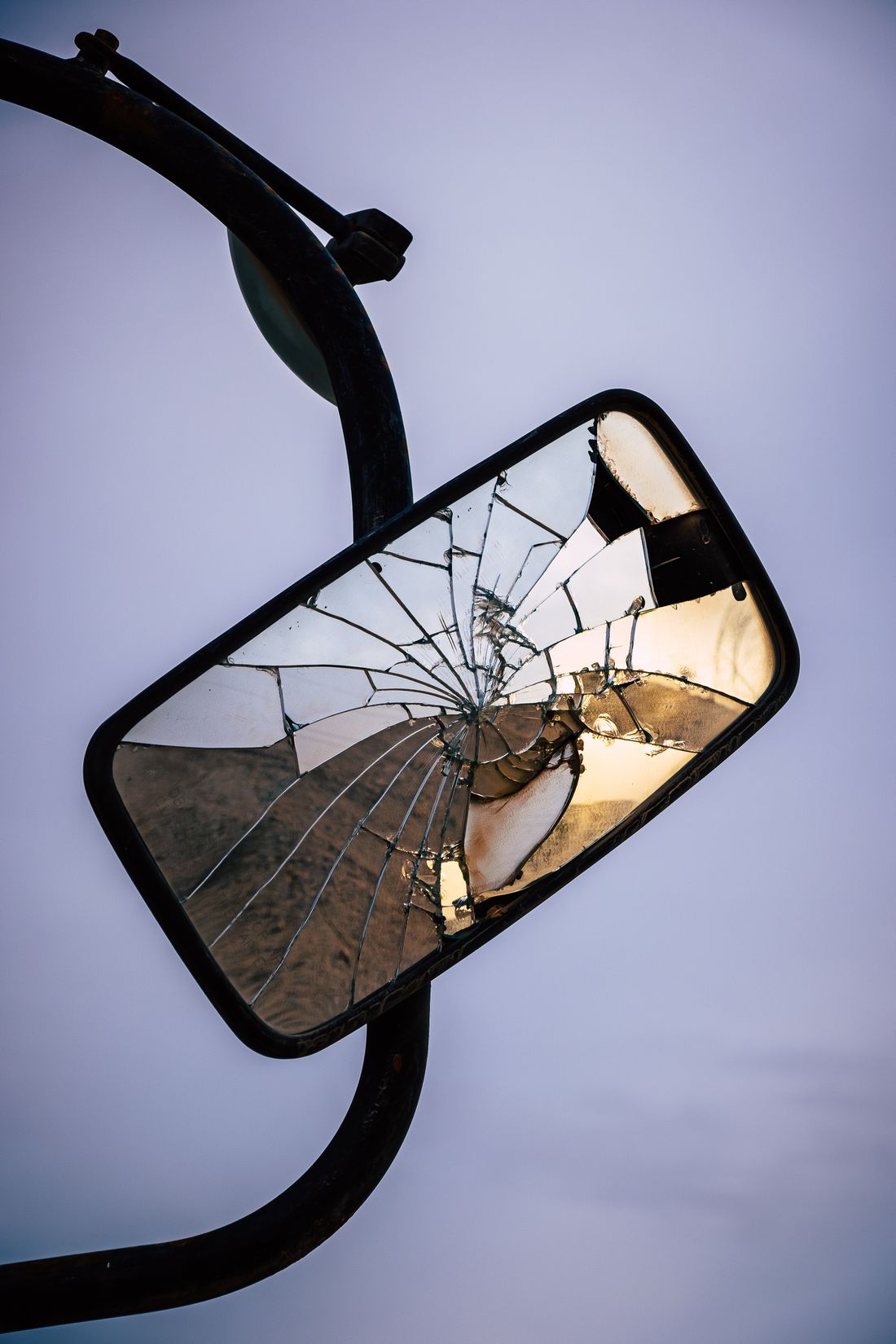 Shattered mirror with a warped golden reflection